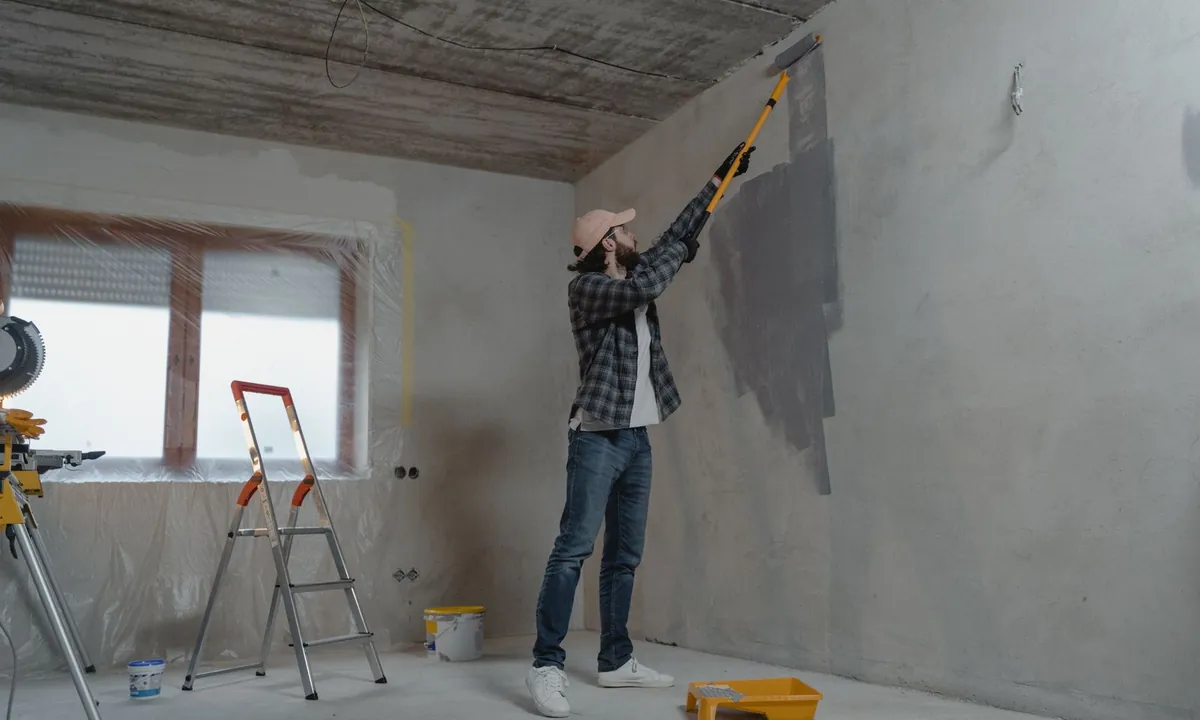 Peinture d’un mur intérieur au rouleau dans une pièce en rénovation